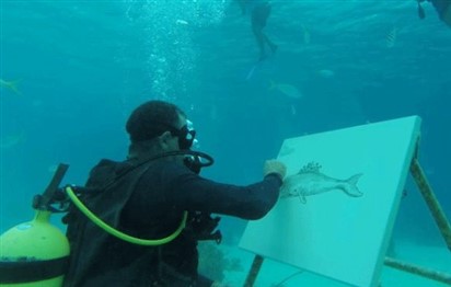 You are currently viewing Cuban artist sketches under the sea among fish and coral reefs